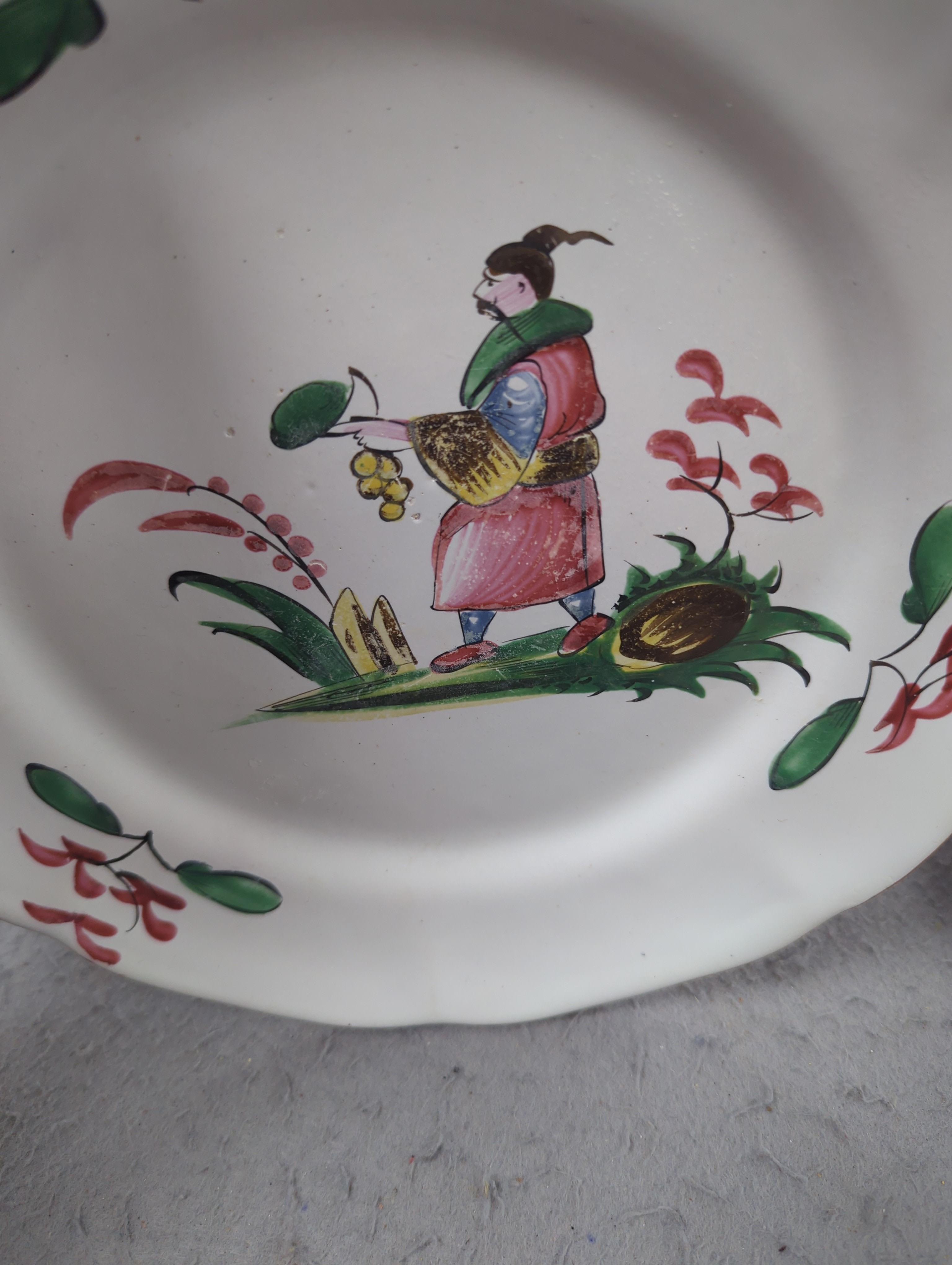 An 18th century Delft plate and three 19th century faience plates, largest 26cm diameter (4)